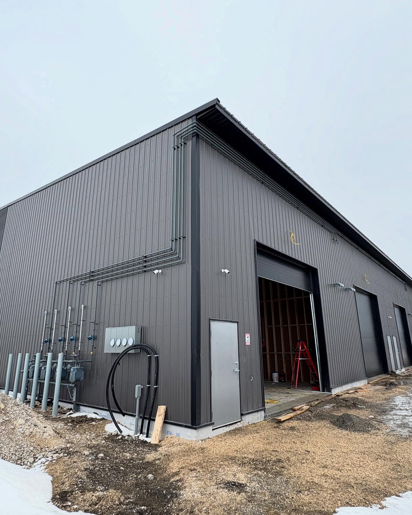 Commercial gas fitting installation by Patterson Mechanical - exterior gas piping on a Manitoba commercial building